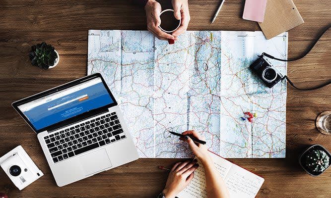 People planning their travel plans on a map 